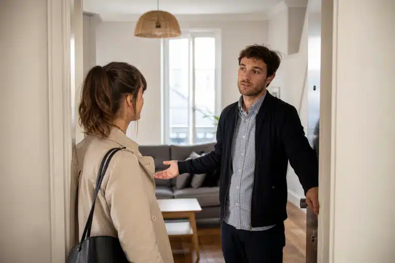 Homme faisant un geste vers une femme dans un salon