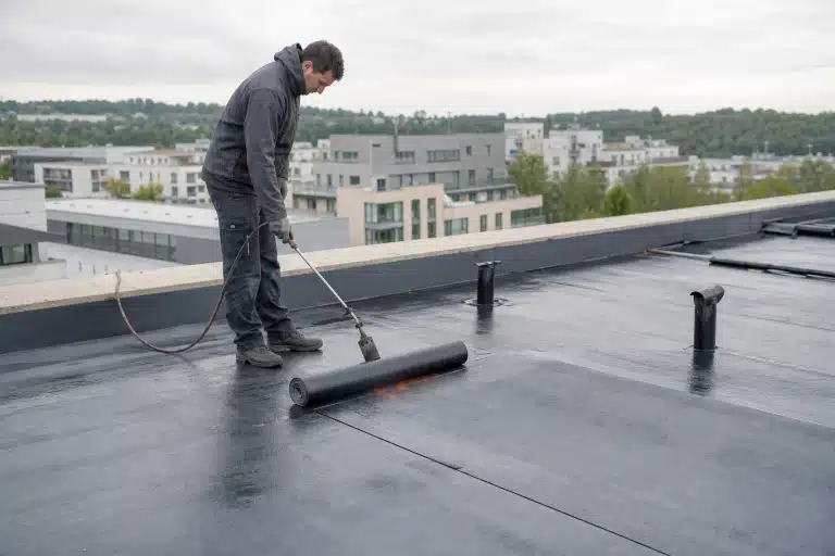 Ouvrier soudant une membrane d'étanchéité sur toit plat